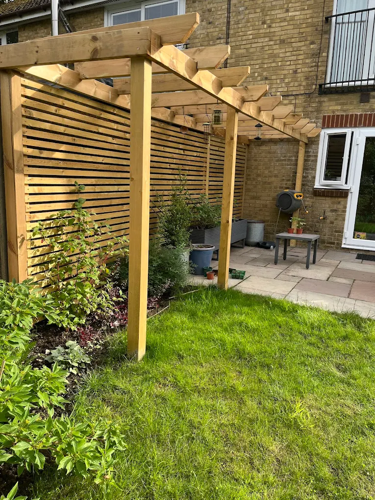Timber pergola and slatted screen built beside a planted garden border